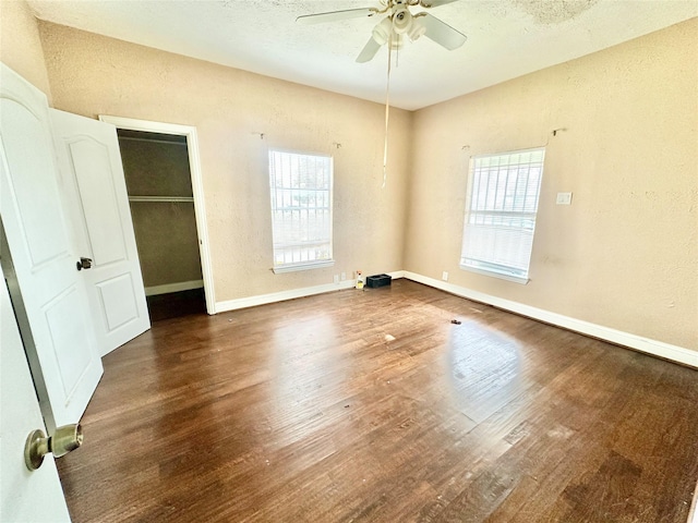 unfurnished room featuring ceiling fan, a textured wall, wood finished floors, and baseboards