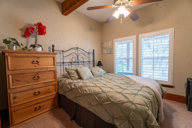 carpeted bedroom featuring ceiling fan, multiple windows, beam ceiling, and baseboards