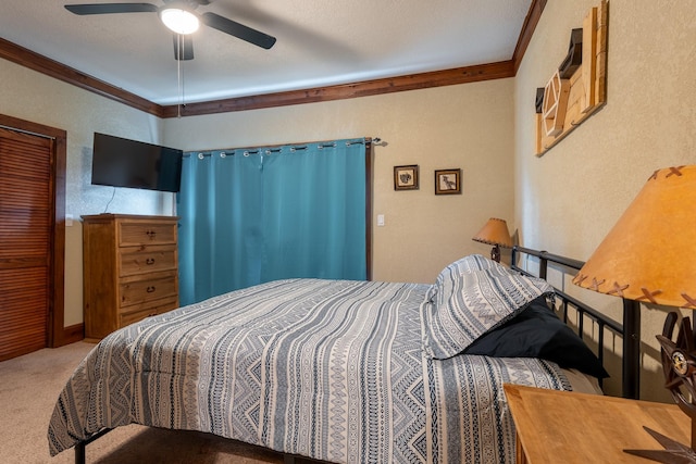 bedroom with a textured wall, carpet flooring, a ceiling fan, and crown molding