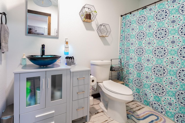 full bathroom featuring curtained shower, marble finish floor, vanity, and toilet