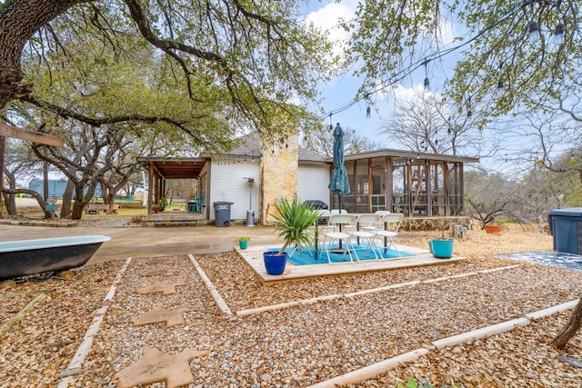 rear view of property featuring a sunroom and a patio