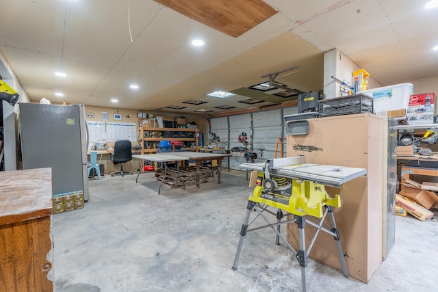 garage featuring a workshop area and freestanding refrigerator