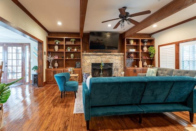 living room with a healthy amount of sunlight, a fireplace, and beam ceiling