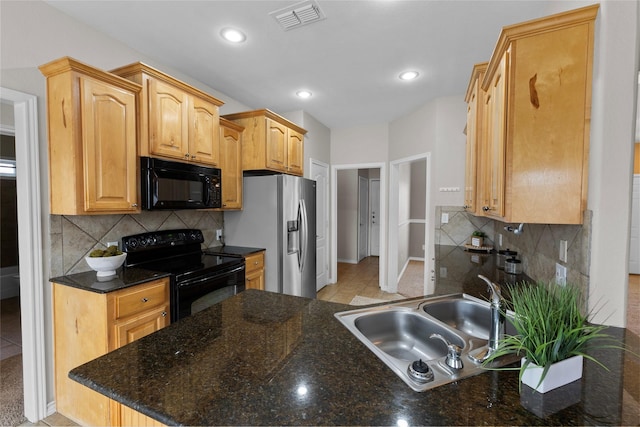 kitchen featuring recessed lighting, a sink, visible vents, black appliances, and tasteful backsplash