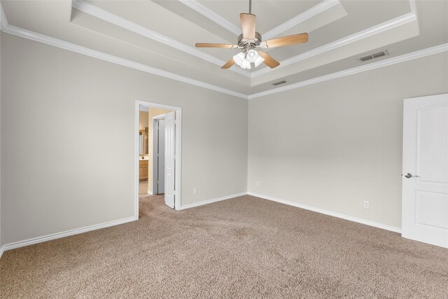 carpeted spare room with a tray ceiling, visible vents, and baseboards