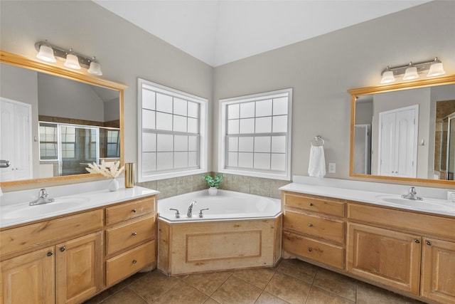 bathroom with a stall shower, two vanities, and a sink