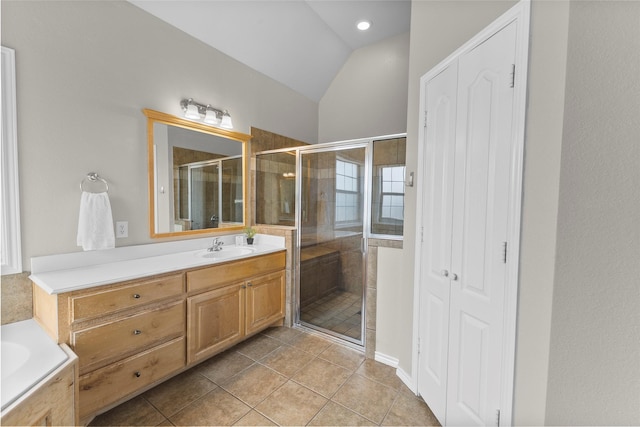 bathroom with a bathtub, lofted ceiling, a shower stall, vanity, and tile patterned flooring