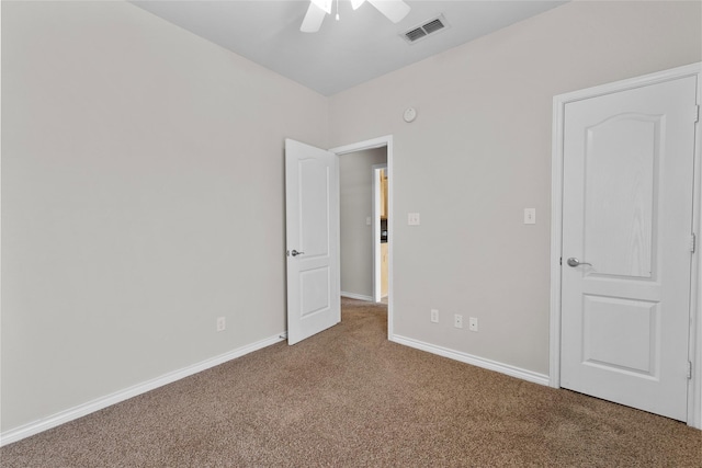 unfurnished bedroom with a ceiling fan, carpet flooring, visible vents, and baseboards