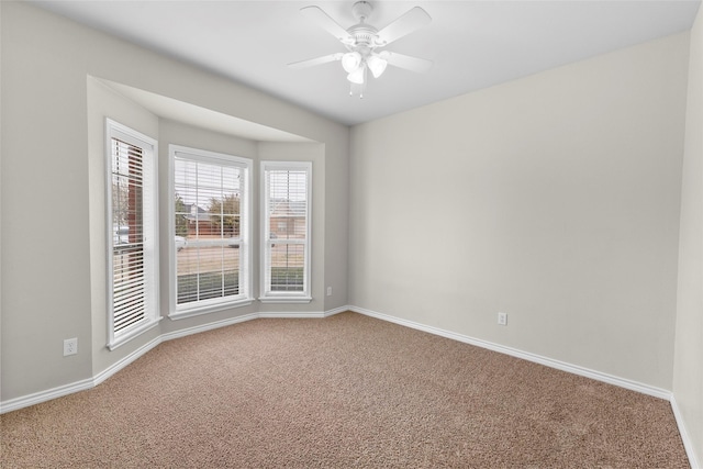 spare room with ceiling fan, carpet, and baseboards