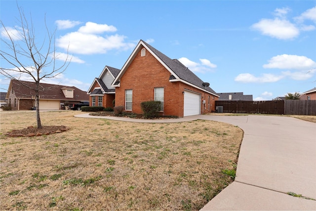 view of home's exterior featuring an attached garage, brick siding, fence, a yard, and concrete driveway