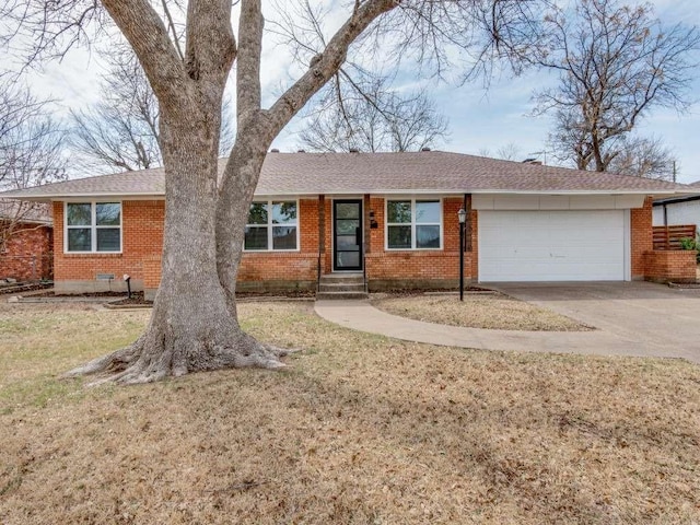 single story home featuring driveway, brick siding, an attached garage, and a front yard