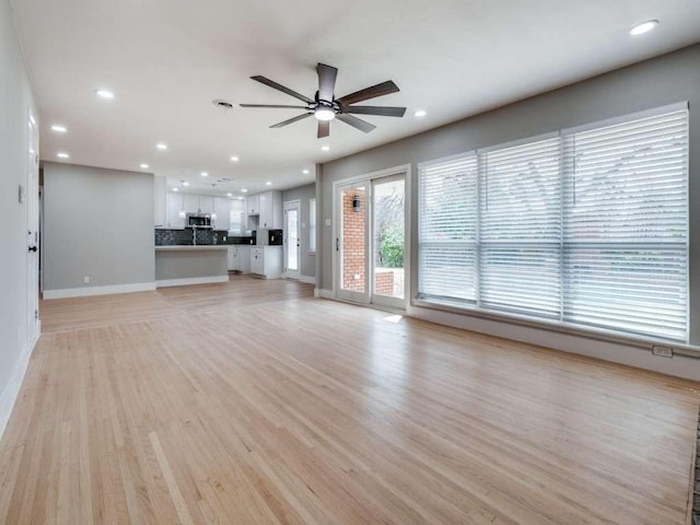 unfurnished living room with light wood-style floors, baseboards, ceiling fan, and recessed lighting