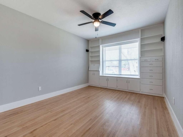 empty room with light wood-style floors, baseboards, and ceiling fan