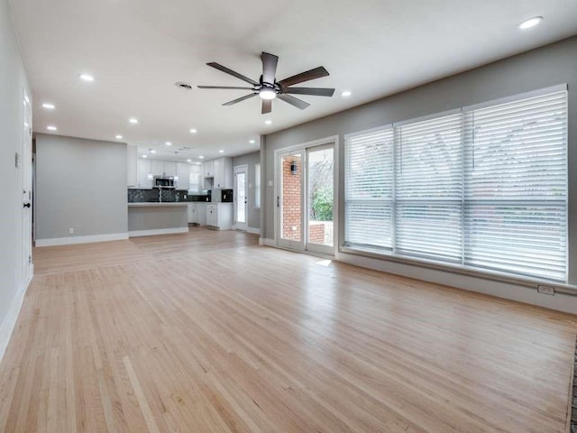 unfurnished living room with light wood-type flooring, ceiling fan, baseboards, and recessed lighting