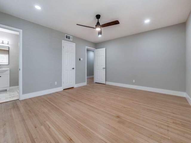 unfurnished bedroom featuring baseboards, visible vents, and light wood finished floors