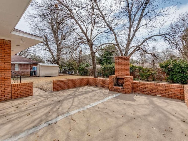 view of patio with an outdoor structure, a fenced backyard, and a storage shed