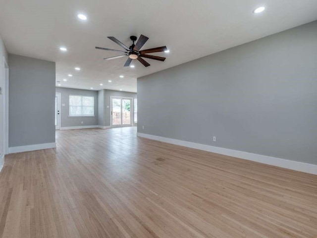 empty room featuring light wood-style floors, baseboards, and recessed lighting