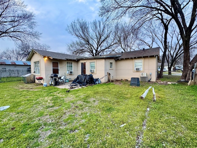 rear view of property with a yard, a patio, fence, and stucco siding