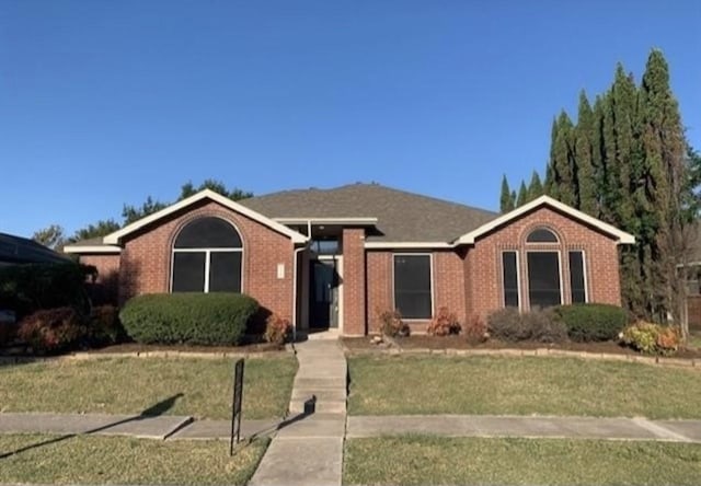 view of front of home with a front yard and brick siding