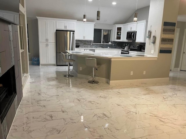 kitchen featuring stainless steel appliances, a breakfast bar, marble finish floor, and white cabinetry