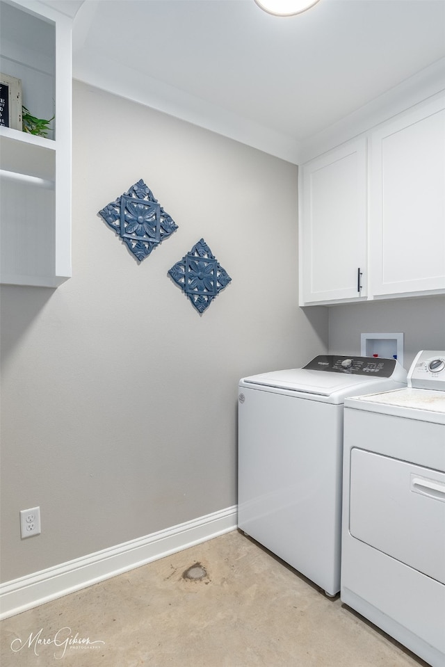 laundry room featuring separate washer and dryer, cabinet space, and baseboards