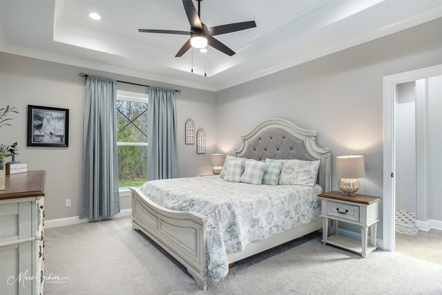 bedroom featuring a tray ceiling, light colored carpet, and baseboards