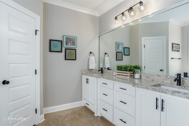 full bath featuring double vanity, ornamental molding, and a sink