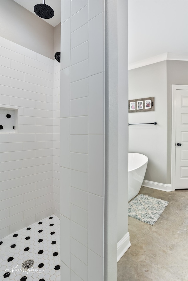 bathroom featuring a soaking tub, a tile shower, and baseboards