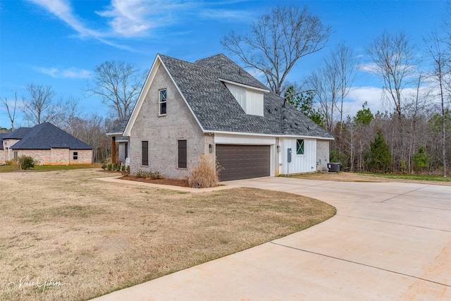 view of front of house featuring board and batten siding, a front yard, concrete driveway, and brick siding