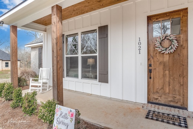doorway to property with a porch and board and batten siding