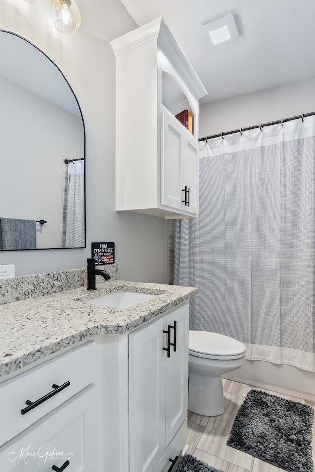 bathroom with toilet, shower / tub combo with curtain, and vanity