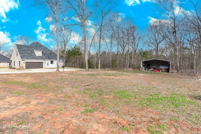 view of yard with driveway and a detached carport