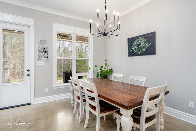 dining room with finished concrete flooring, a healthy amount of sunlight, ornamental molding, and baseboards