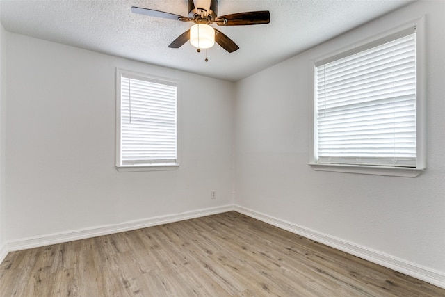 unfurnished room with light wood-type flooring, baseboards, a ceiling fan, and a textured ceiling