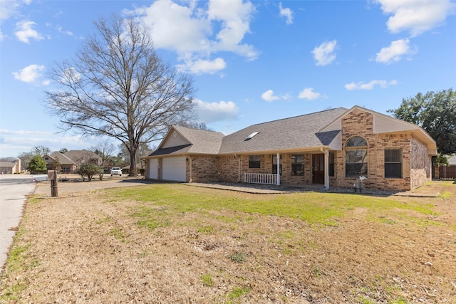 view of front of home with a front lawn, brick siding, a shingled roof, and an attached garage