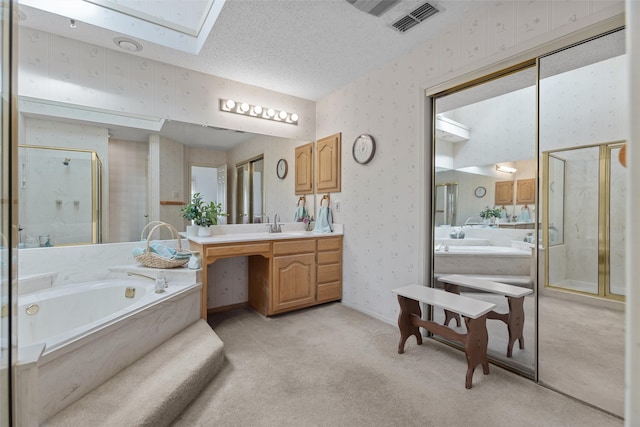 full bathroom with a textured ceiling, a stall shower, a skylight, and wallpapered walls