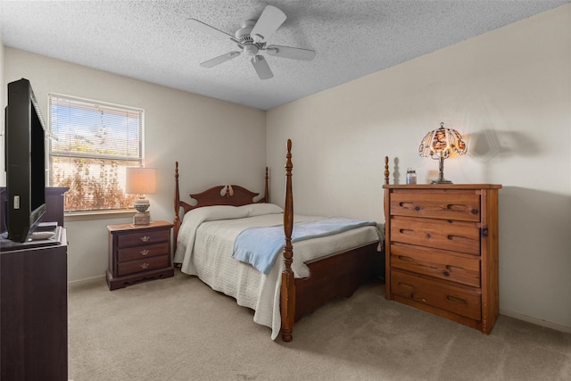 bedroom with light carpet, ceiling fan, a textured ceiling, and baseboards