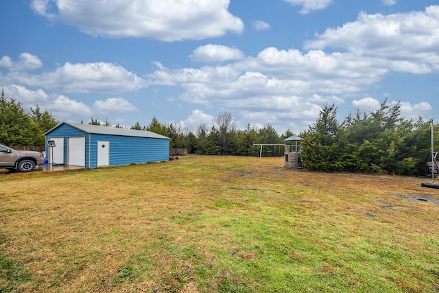 view of yard with a detached garage and an outdoor structure