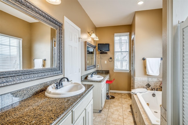 full bath featuring two vanities, a sink, a jetted tub, and tile patterned floors