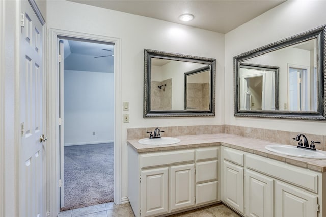 bathroom featuring double vanity, walk in shower, a sink, and tile patterned floors