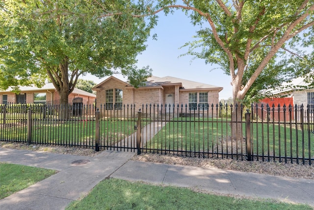 view of front of property with brick siding, a fenced front yard, and a front yard