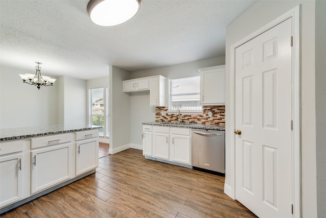 kitchen with decorative backsplash, light wood-style floors, white cabinets, a sink, and dishwasher