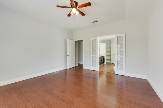 unfurnished bedroom with visible vents, baseboards, wood finished floors, a spacious closet, and french doors