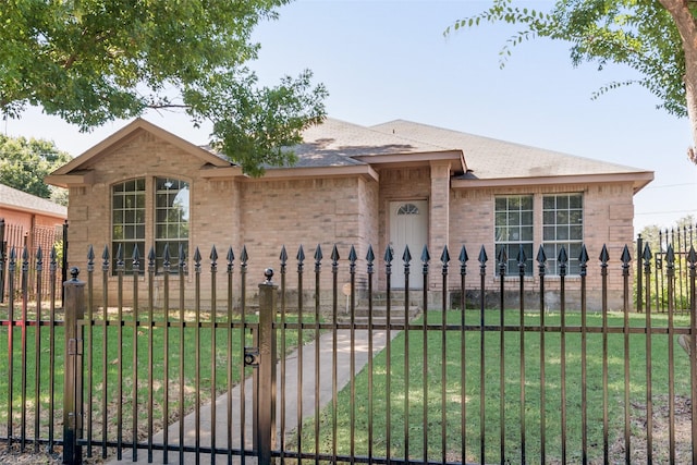 view of front facade featuring a front lawn, a fenced front yard, and brick siding