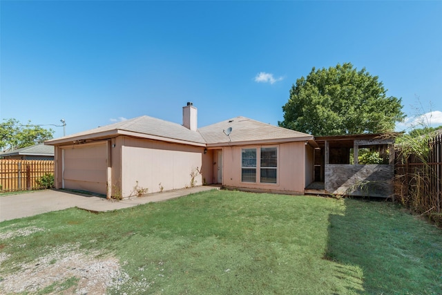 rear view of house with a garage, concrete driveway, a chimney, and fence