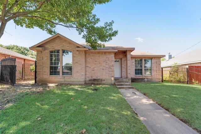 ranch-style home featuring brick siding, fence, and a front yard