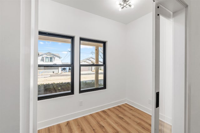 spare room with light wood-type flooring and baseboards