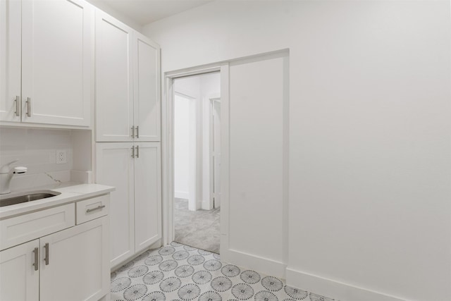 interior space with baseboards and a sink