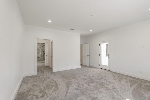 empty room with recessed lighting, visible vents, light colored carpet, and baseboards