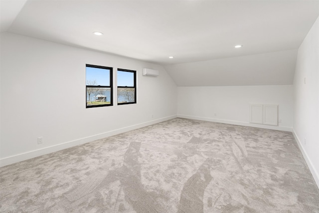 additional living space with an AC wall unit, recessed lighting, carpet floors, baseboards, and vaulted ceiling